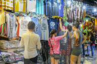 Girl tourists browse souvenir clothes in the Art Center Night Market in the centre of this NW tourist town; Siem Reap, Cambodia