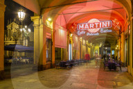 View of Martini Cafe under the arches in shopping arcade at night, Turin, Piedmont, Italy, Europe