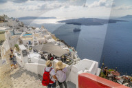 View of Fira restaurants and cruise ship, Firostefani, Santorini (Thira), Cyclades Islands, Greek Islands, Greece, Europe