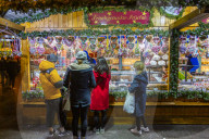 People at Christmas market stall at night in Rathausplaza, Vienna, Austria, Europe