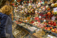 People at Christmas market stall at night in Rathausplaza, Vienna, Austria, Europe