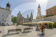 View of cyclist and Salzburg Cathedral in Residenzplatz, Salzburg, Austria, Europe