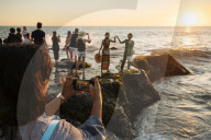 Tourists enjoying sunset at Tanah Lot Temple, Bali, Indonesia