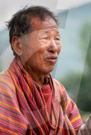 Portrait elderly Bhutanese man wearing prayer beads.