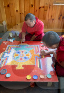 Bhuddist monks making a diorama with coloured sand. Once made, the diorama is wiped off, their belief: nothing lasts forever.