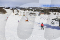 Bjorli Village, skiers, piste and chair lift, early snow ski resort, Winter sun, Gudbrandsdalen Valley, Oppland, Norway