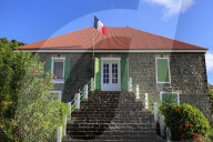 Old Swedish Jail, French flag, flowering shrubs, Gustavia, St. Barthelemy (St. Barts, St Barth), West Indies, Caribbean
