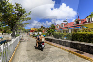 Couple on moped, colourful Bourg des Saintes town, Terre de Haut, Iles Des Saintes, Les Saintes, Guadeloupe, Caribbean