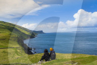 Two young hikers taking a rest on a walking trail along the Antrim coast, Northern Ireland