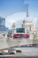 London bus crossing Waterloo bridge with the dome of St. Paul's behind