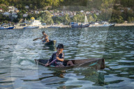 Indonesia, Spice Islands, Banda Besar. Local children in locally made dugout wooden canoes
