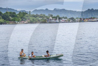 Indonesia, Spice Islands, Rhun. Local boys in a wooden canoe.