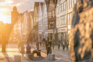 Tourists in Bryggen Old Town at sunset, Bergen, Hordaland County, Norway