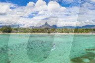 Windsurf in the lagoon facing Flic en Flac beach and Piton de la Petite Riviere Noire mount, Black River, Mauritius (drone)
