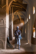 Imam praying in a beautiful Hausa syle architecture mosque in Yaama, Niger