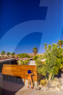 View of beautiful desert home and woman getting a tan.