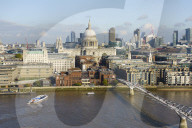 High view of St. Paul's Cathedral and City of London skyline with River Thames and Millennium Bridge in foreground, London