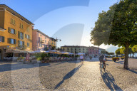 Colourful square of the village of Colico with transit of tourists. Como Lake, Lombardy, Italy, Europe.