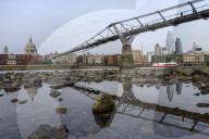 Millennium Bridge and city overview at low tide, London, England