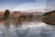 Partially frozen Kelly Hall Tarn and view of Coniston Old Man, Lake District, Cumbria