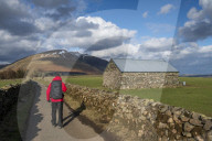 Walker on road leading to Blencathra, Lake District National Park, Cumbria