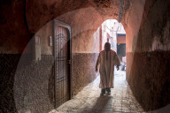 Local man dressed in traditional djellaba walking through archway in a street in the Kasbah, Marrakech, Morocco, North Africa, Africa