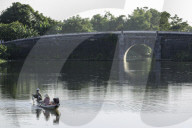 A man and woman fishing from a small boat in the moat around the Citadel in Hue