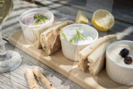 Meze at a Cypriot restaurant of Taramasalata, tzatziki, hummus, pitta bread, lemon and olives accompanied with white wine, Cyprus