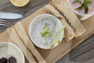 Meze at a Cypriot restaurant of Taramasalata, tzatziki, hummus, pitta bread, lemon and olives accompanied with white wine, Cyprus