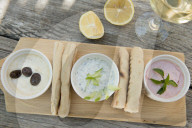 Meze at a Cypriot restaurant of Taramasalata, tzatziki, hummus, pitta bread, lemon and olives accompanied with white wine, Cyprus