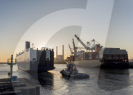 Port area of le Havre showing container ship, heavy lift dock cranes and iconic twin chimneys