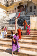 Women in brightly coloured saris walking down the ghats (steps down to the sacred water of Pushkar Lake), no shoes allowed.