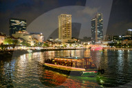 Tourist boat near the historic Boat Quay in Singapore river at dusk