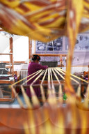 Uyghur woman preparing loom with tie dyed silk thread ready for weaving, Jiya, Xinjiang, China