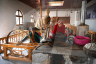 Uyghur women spinning silk thread from cocoons in traditional silk workshop, Jiya, Xinjiang, China
