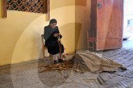 Uyghur woman stripping bark from Mulberry branches for paper making, Hotan, Xinjiang, China