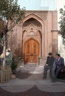 Two Utghur Muslim men sitting outside city centre mosque, Kashgar, Xinjiang, China