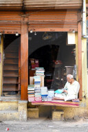 Bookseller sitting outside his bookshop in old Ahmedabad, Gujarat, India