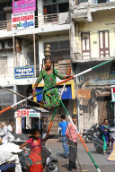 Young girl performing on a tightrope erected in a busy street to earn money, old Ahmedabad, Gujarat, India