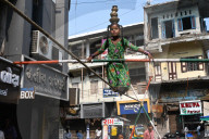 Young girl performing on a tightrope erected in a busy street to earn money, old Ahmedabad, Gujarat, India