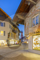 View of Parish Church of St. Martin and town shops at dusk, Garmisch-Partenkirchen, Bavaria, Germany