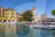View of boats and Castello di Sirmione on a sunny day, Sirmione, Lake Garda, Province of Verona, Italy, Europe