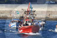 The Virgen del Carmen, wrapped in protective plastic, is carried out to sea from Tarifa, accompanied by a flotilla of boats