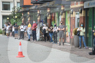 Young people queue outside Greenwich pharmacy to get vaccinated.