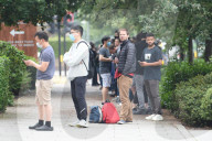 Young people queue outside Greenwich pharmacy to get vaccinated.