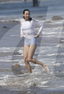 A makeup free Minnie Driver, 51,  seen spending time with friends sunbathing and swimming on the beach in Malibu. 