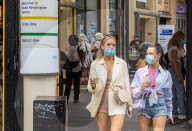 Members of the public wear masks in London today.