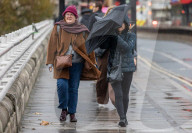 Christmas shoppers struggle in the wind on Waterloo Bridge, London
