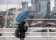 Christmas shoppers struggle in the wind on Waterloo Bridge, London