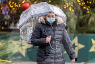 Members of the public brave the rain while shopping London.
